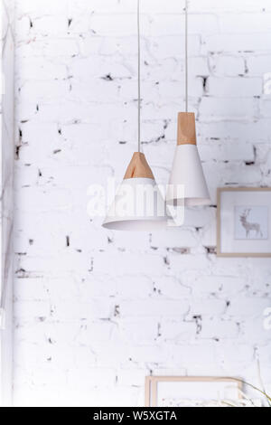 two hanging lamps , Electric light bulb.White modern ceiling lamp on wall background.white brick wall interior decor. Scandinavian style, modern eco Stock Photo