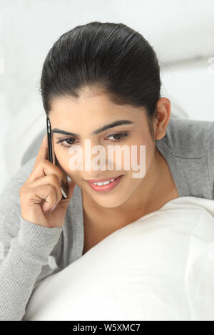 Indian young woman talking on a mobile phone and smiling Stock Photo