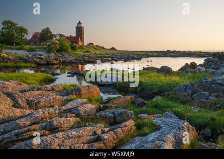 Svaneke Gamle Fyr lighthouse and rocky coastline along east coast at sunrise, Svaneke, Bornholm Island, Baltic sea, Denmark, Europe Stock Photo