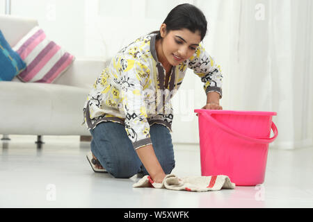 Woman wiping floor and smiling Stock Photo