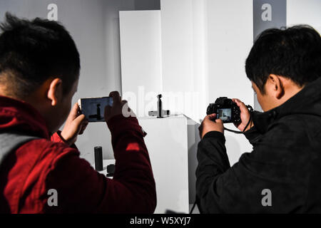Visitors takes photos of a DJI Osmo Pocket during the new product launch event at the Museum of International Brewmaster Art (MIBA) in Beijing, China, Stock Photo