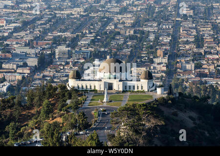 Los Angeles, California, USA - July 28, 2019:  Early morning view of Griffith Park Observatory with urban city streets and buildings in background. Stock Photo