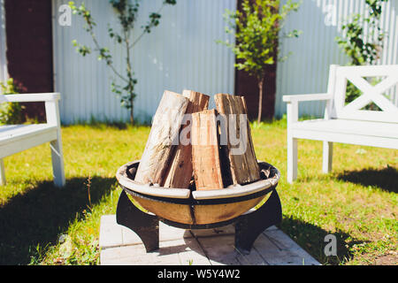 Close-up, roaring fire with blurred flames from wood logs in a stone firepit. Stock Photo