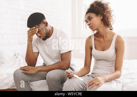 Thoughtful girl undergoing pregnancy test near boyfriend Stock Photo