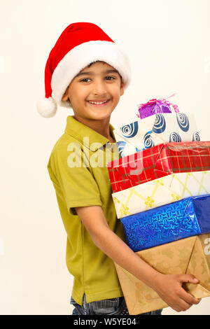 Boy holding stack of gifts and smiling