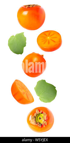 Isolated flying fruit. Falling persimmon with leaf isolated on white background with clipping path as package design element and advertising. depth fo Stock Photo