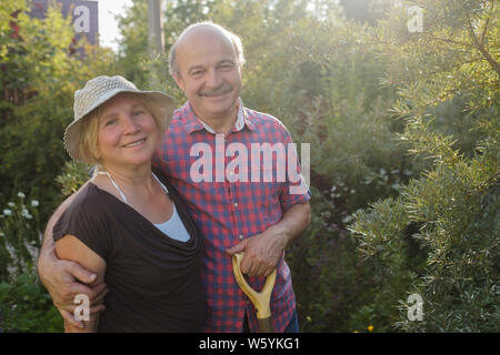 Cheerful mature couple resting in green summer garden Stock Photo