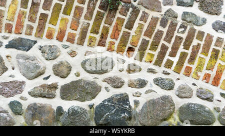 wall of field stones and colored bricks Stock Photo