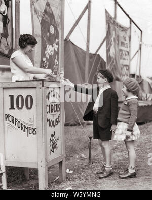 1930s SMILING BOY AND GIRL BROTHER SISTER BUYING TICKET FROM WOMAN