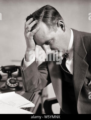 1930s WORRIED DEPRESSED MAN BUSINESSMAN WEARING SUIT TIE SITTING RESTING ELBOW ON DESK TOP HOLDING HEAD IN HAND LOOKING DOWN  - c5173 HAR001 HARS OLD FASHION 1 FACIAL FEAR COMPETITION WORRY LIFESTYLE MOODY HALF-LENGTH PERSONS CARING MALES RISK EXPRESSIONS TROUBLED B&W RESTING SADNESS SUIT AND TIE DISASTER SELLING WELLNESS HEAD AND SHOULDERS STRENGTH IN ON ELBOW FEELING MOOD OCCUPATIONS CONCEPTUAL GLUM ESCAPE EMOTION EMOTIONAL EMOTIONS LOOKING DOWN MID-ADULT MID-ADULT MAN MISERABLE SALESMEN SOLUTIONS BLACK AND WHITE CAUCASIAN ETHNICITY HAR001 OLD FASHIONED Stock Photo