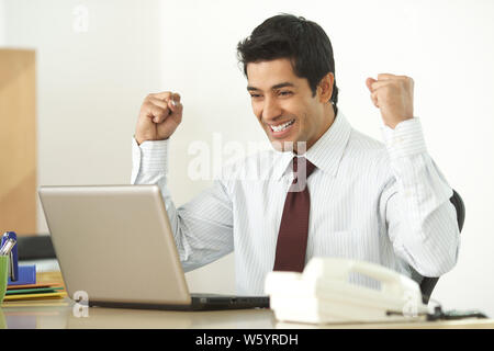 Businessman working on a laptop and smiling Stock Photo