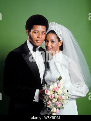1970s PORTRAIT SMILING AFRICAN-AMERICAN BRIDE AND GROOM MAN WEARING TUXEDO WOMAN IN WHITE GOWN VEIL PINK WHITE ROSES BOUQUET  - kb8763 HAR001 HARS YOUNG ADULT PLEASED JOY LIFESTYLE SATISFACTION CELEBRATION FEMALES MARRIED STUDIO SHOT ROSES SPOUSE HUSBANDS COPY SPACE FRIENDSHIP HALF-LENGTH LADIES PERSONS AFRO MALES VEIL CONFIDENCE PARTNER EYE CONTACT DREAMS HAPPINESS CHEERFUL STYLES AFRICAN-AMERICANS AFRICAN-AMERICAN AND HAIRSTYLE BLACK ETHNICITY PRIDE SMILES CONNECTION HEADPIECE JOYFUL STYLISH FASHIONS SIDE BY SIDE SIDEBURNS TOGETHERNESS WIVES YOUNG ADULT MAN YOUNG ADULT WOMAN HAR001 Stock Photo
