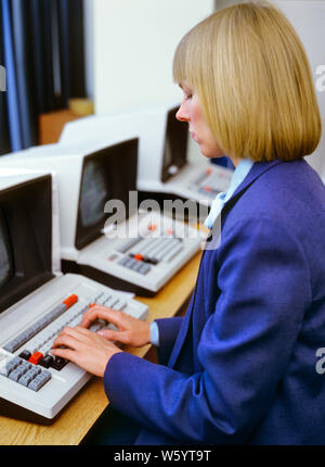 1980s BLOND WOMAN WEARING BLUE SUIT WORKING SITTING AT COMPUTER TERMINAL TYPING HANDS ON KEYBOARD - ko1301 PHT001 HARS HISTORY FEMALES JOBS UNITED STATES COPY SPACE HALF-LENGTH LADIES COMPUTERS PERSONS UNITED STATES OF AMERICA CONFIDENCE BUSINESSWOMAN NORTH AMERICA NORTH AMERICAN SKILL OCCUPATION SKILLS HIGH ANGLE EARLY TYPING NETWORKING HAIRSTYLE PROGRESS OPPORTUNITY NYC OCCUPATIONS HIGH TECH CONNECTION HARDWARE NEW YORK CITIES STYLISH BUSINESSWOMEN NEW YORK CITY TEXAS INSTRUMENTS BOB HIGH-TECH MID-ADULT MID-ADULT MAN MID-ADULT WOMAN PAGEBOY TERMINAL CAUCASIAN ETHNICITY OLD FASHIONED Stock Photo