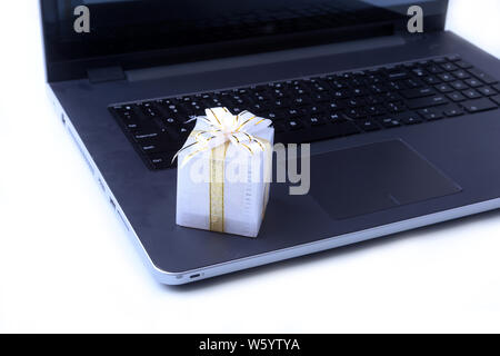 Laptop and christmas gifts box on white desk Stock Photo