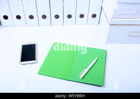File folder with documents and important document with phone and notebook on isolated background Stock Photo