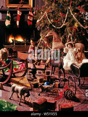 1970s 1980s OLD FASHIONED DECORATED CHRISTMAS TREE WITH POPCORN GARLANDS BY FIREPLACE ANTIQUE TOYS   - kx8773 PHT001 HARS MERRY PORCELAIN MODELS RECREATION TRADITION QUAINT DECEMBER CONCEPTUAL DECEMBER 25 STILL LIFE WARMTH ESTABLISHED GARLANDS ROCKING HORSE STYLISH COLLECTIBLES CREATIVITY JOYOUS PERIOD PINE TREE BABY CARRIAGE COLLECTIBLE FESTIVE OLD FASHIONED Stock Photo