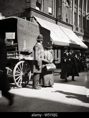 1900s TURN OF THE 20TH CENTURY MAN POLICE OFFICER HELPING SENIOR WOMAN PEDESTRIAN WALKING THROUGH STREET TRAFFIC BOSTON MA USA - q74191 CPC001 HARS OLD TIME NOSTALGIA OLD FASHION 1 POLICEMAN WAGON THROUGH CAREER SECURITY SAFETY BOSTON MYSTERY ABSTRACT LIFESTYLE ARCHITECTURE ELDER FEMALES JOBS UNITED STATES COPY SPACE FULL-LENGTH LADIES PERSONS INSPIRATION UNITED STATES OF AMERICA MALES RISK OFFICER BUILDINGS PROFESSION B&W NORTH AMERICA COP MASSACHUSETTS PROTECT AND SERVE NORTH AMERICAN SKILL OCCUPATION PEDESTRIAN SKILLS OLD AGE OLDSTERS OLDSTER EARLY PROPERTY PROTECTION Stock Photo