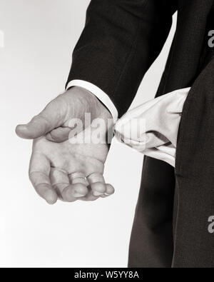 1960s MALE HAND TURNING PANTS POCKET INSIDE OUT SHOWING EMPTY POCKET - s13821 HAR001 HARS DESTITUTE INSIDE OUT INSIDE-OUT MID-ADULT MID-ADULT MAN RECESSION BLACK AND WHITE CAUCASIAN ETHNICITY HANDS ONLY HAR001 HOPELESS OLD FASHIONED REPRESENTATION Stock Photo