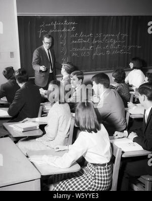 1960s MAN TEACHER IN HIGH SCHOOL CLASSROOM TEACHING A CIVICS OR HISTORY CLASS  WITH COED TEENAGE STUDENTS - s15388 HAR001 HARS NOSTALGIA OLD FASHION 1 JUVENILE TEACHERS COMMUNICATION INFORMATION LIFESTYLE HISTORY FEMALES JOBS COPY SPACE HALF-LENGTH PERSONS INSPIRATION MALES TEENAGE GIRL TEENAGE BOY CONFIDENCE B&W SKILL OCCUPATION SKILLS HIGH ANGLE INSTRUCTOR KNOWLEDGE OPPORTUNITY AUTHORITY HIGH SCHOOL OCCUPATIONS POLITICS HIGH SCHOOLS EDUCATOR TEENAGED OR EDUCATING EDUCATORS INSTRUCTORS JUVENILES MID-ADULT MID-ADULT MAN MID-ADULT WOMAN SCHOOL TEACHES TOGETHERNESS BLACK AND WHITE Stock Photo