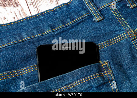 black smartphone sticking out of his jeans pocket Stock Photo