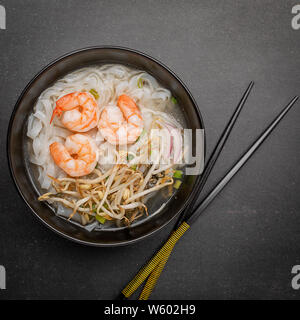 Vietnamese Pho tom noodle broth asian soup prawn. Top view with copy space on dark or black background Stock Photo