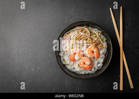Vietnamese Pho tom noodle broth asian soup prawn. Top view with copy space on dark or black background Stock Photo