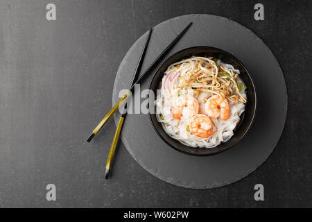 Vietnamese Pho tom noodle broth asian soup prawn. Top view with copy space on dark or black background Stock Photo