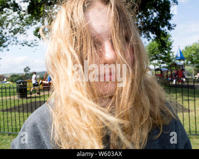 Blonde Teenage girl messing around with her messy hair Stock Photo