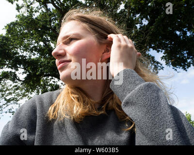 Blonde Teenage girl messing around with her messy hair Stock Photo