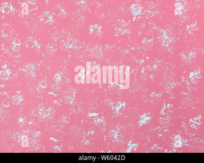 Abstract pastel pink background with white spots. Chaotic spots of white dye on the painted with a pink color surface. Acrylic paints. Top view. Stock Photo