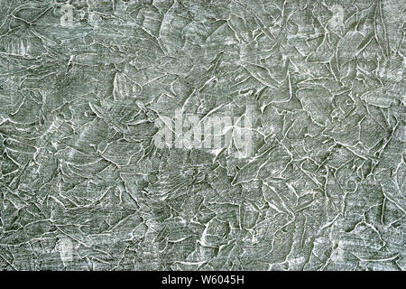Rough dark textured surface is slightly painted with white paint. Abstract scrathed background pattern, acrylic paints. Top view. Stock Photo