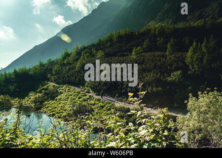 Two hikers in High Tatras mountains during sunrise Stock Photo