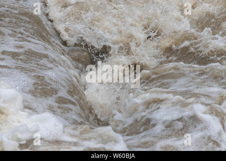 Powerful current flowing over uneven terrain after heavy rain Stock Photo