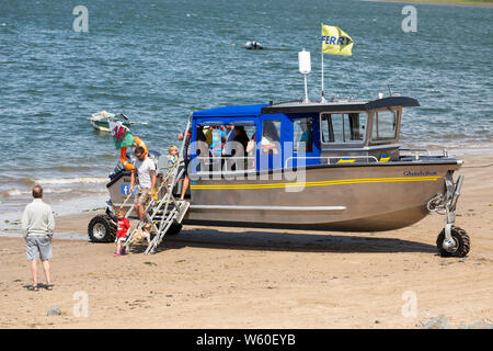 Passengers disembark at Ferryside from Glansteffan, the amphibious ferry boat operating across the Tywi river between Ferryside (Glan-y-Fferi) and Lla Stock Photo