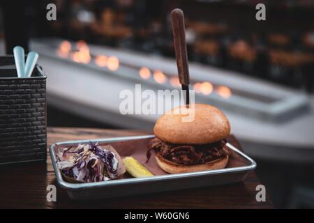 Knife stuck in a burger on a metal tray on the roof Stock Photo