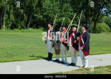 Reenactors in Continental Army uniforms line up in a military formation during an event at Historic Fort Wayne in Fort Wayne, Indiana, USA. Stock Photo