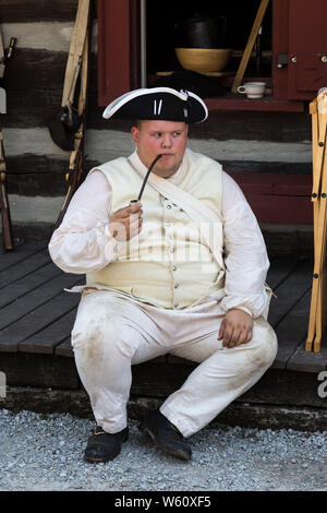 A reenactor smokes a pipe while taking a break during an event at Historic Old Fort Wayne in Fort Wayne, Indiana, USA. Stock Photo