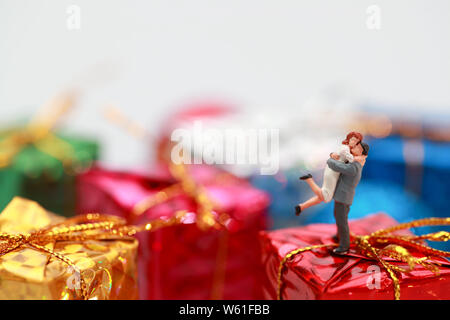 Miniature people: a couple celebrating on christmas gift boxes Stock Photo
