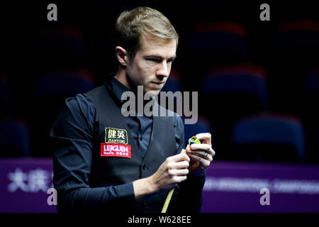 Jack Lisowski of England chalks his cue as he considers a shot to Marco Fu of Chinese Hong Kong in their second round match during the 2018 OPPO Inter Stock Photo