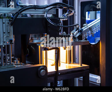 Raw material of PET plastic bottle on blowing machine pre-heat process Stock Photo