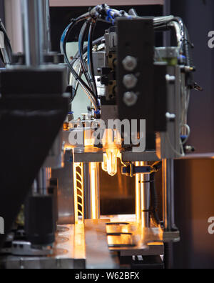 Raw material of PET plastic bottle on blowing machine pre-heat process Stock Photo