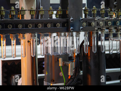Raw material of PET plastic bottle on blowing machine pre-heat process Stock Photo