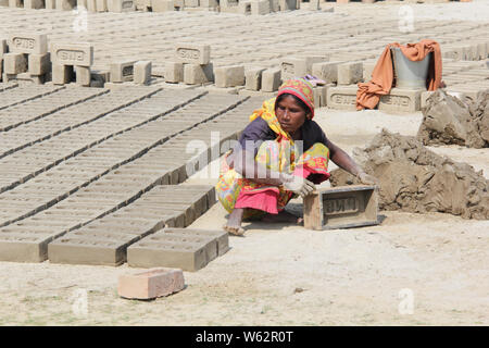 Woman making bricks Stock Photo
