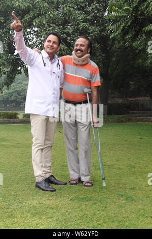 Physiotherapist showing something to his patient in a lawn Stock Photo