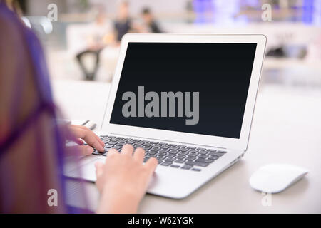 Isolated mockup image of laptop and female hand typing to blank screen laptop. Freelancer or student working on new project. Business concept. Stock Photo