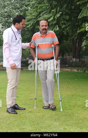 Physical therapist helping patient in walk Stock Photo