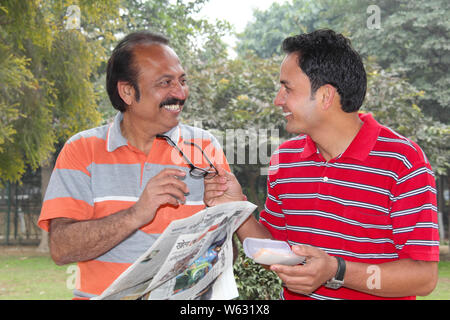 Man giving eyeglasses with his father and smiling Stock Photo