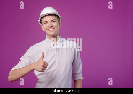 young funny smiling man in white helmet on purple background Stock Photo