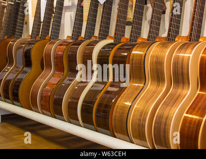 Row of acoustic guitars standing in a store Stock Photo