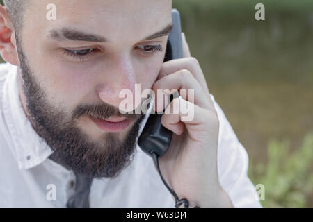 Bearded man in office clothes talking on the phone. close-up Stock Photo